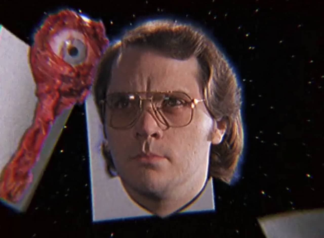 floating head of Garth Marenghi in field of stars with a floating eye behind it