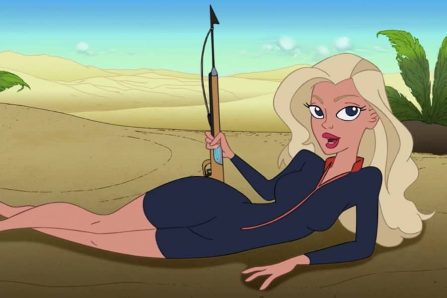 a blonde woman lying on the beach and holding a spear gun