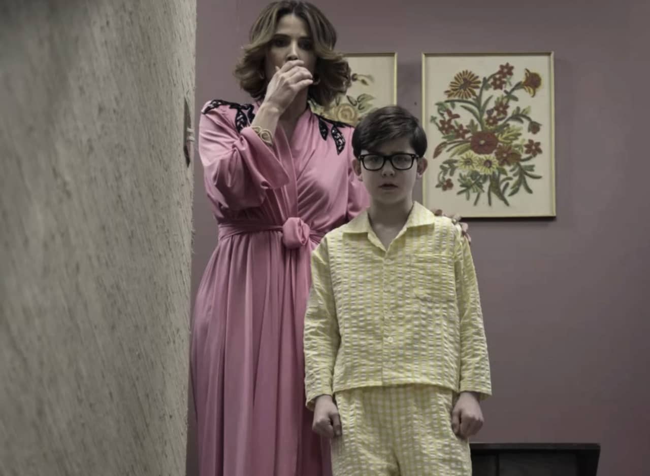 Cobie Smulders as young Lucille Bluth, covering her mouth in horror as young Buster stands in front of her