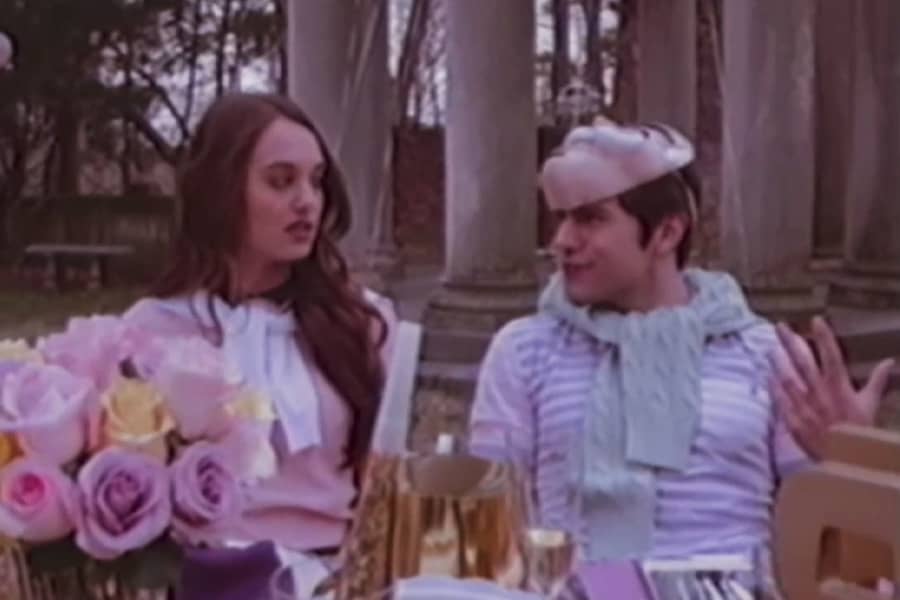 two yuppie teens sit at a fancy table set for a party