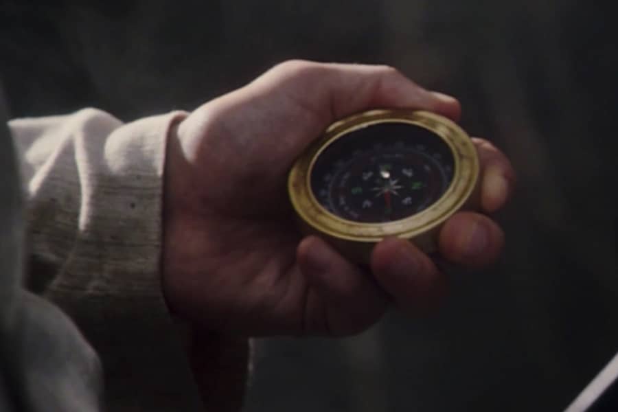 a hand holds a compass
