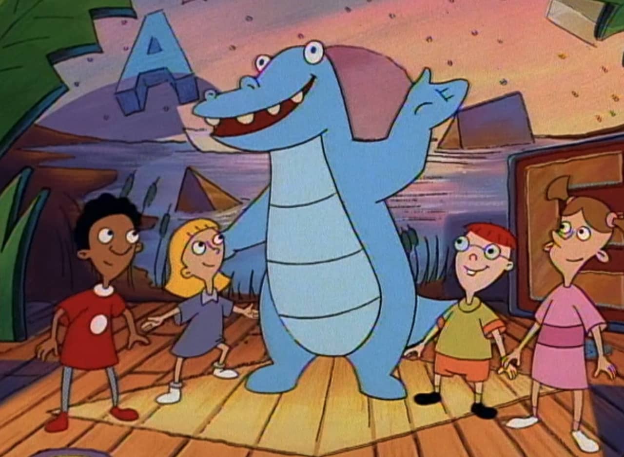blue dinosaur with a group of kids on a tv set