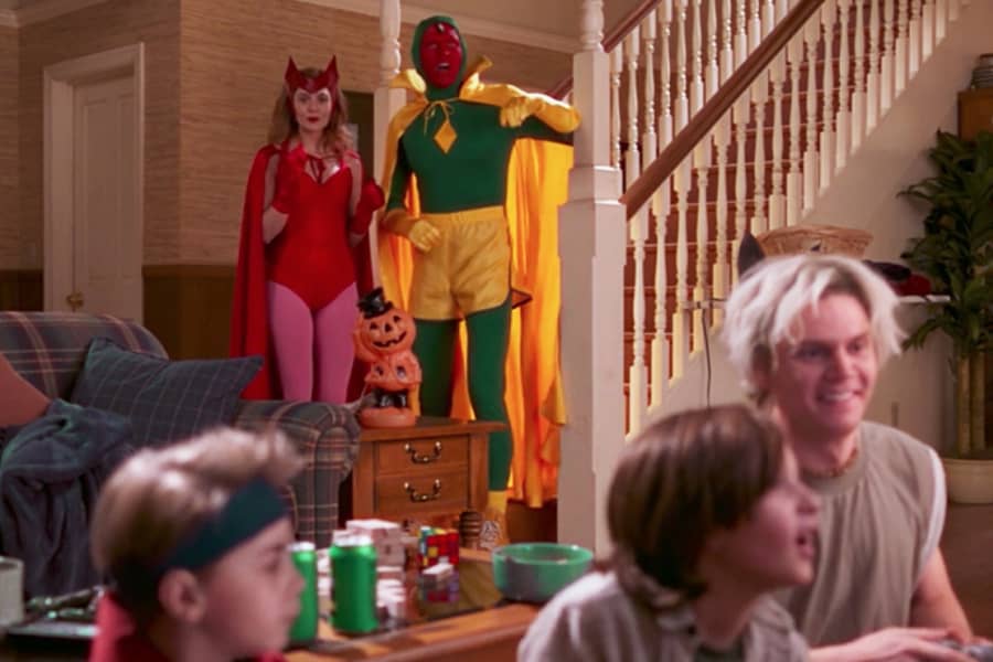 Wanda and Vision dressed in comic-style costumes while their kids play with Uncle Pietro