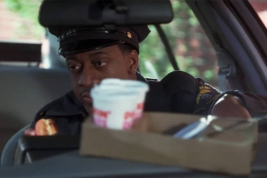 a man, Fowl sitting in a cop car with coffee cups on the dash