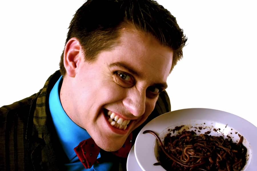 host smiling next to a plate of worms and dirt