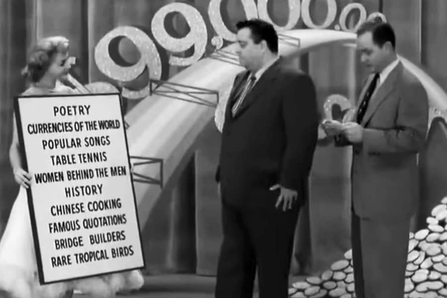 Norris, a contestant, and an assitant holding a board full of categories