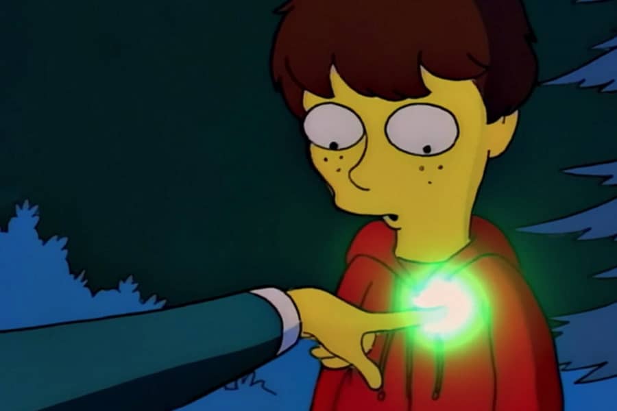 a man points at the heart of a small boy, his finger glowing green and bright