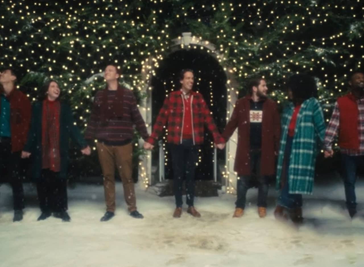 seven men and women hold hands in the snow
