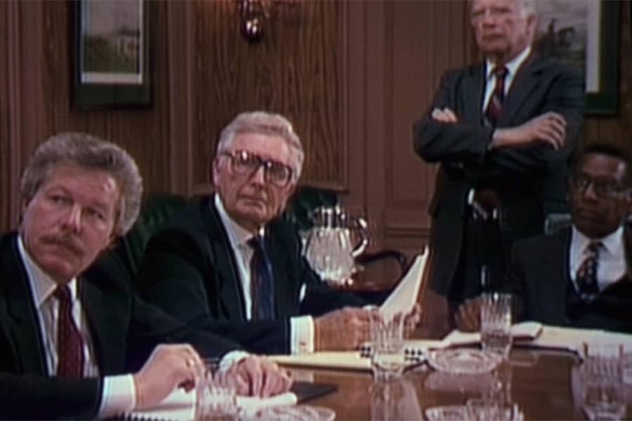 old men in suits around a conference table