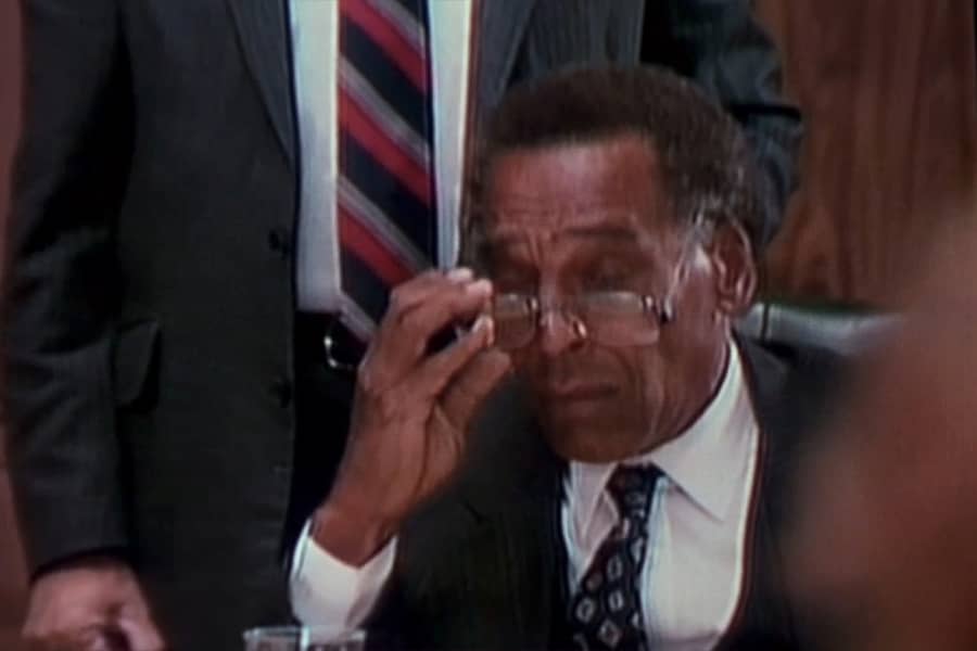 Black man removing his glasses in shock
