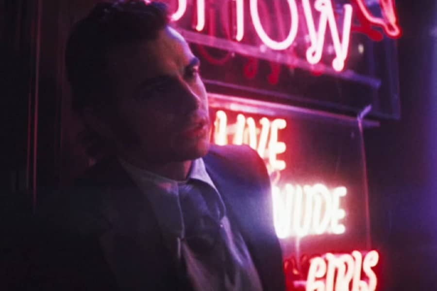 Dave Franco against some neon signs