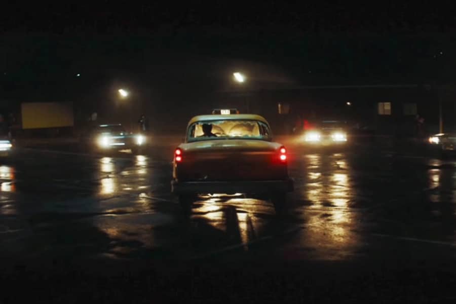 taxi with shot out rear window surrounded by cars