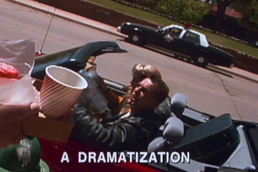 man and woman in convertable as part of a dramatization