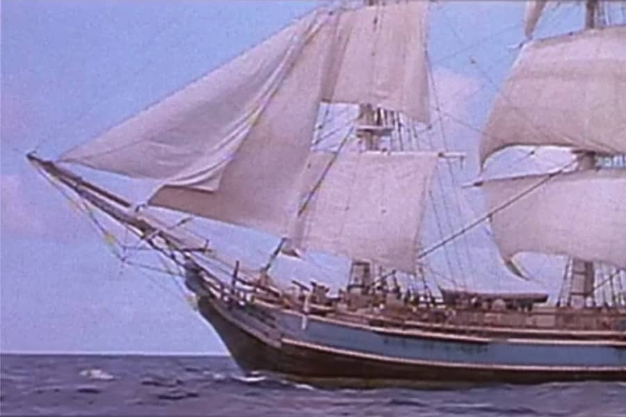 a ship with large sails on the ocean