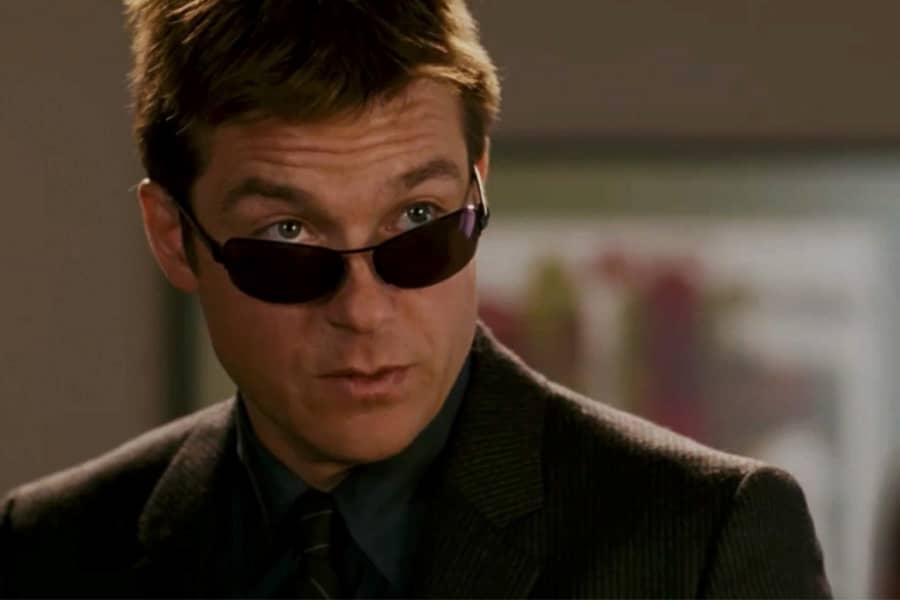 Jason Bateman peers out over a pair of sunglasses