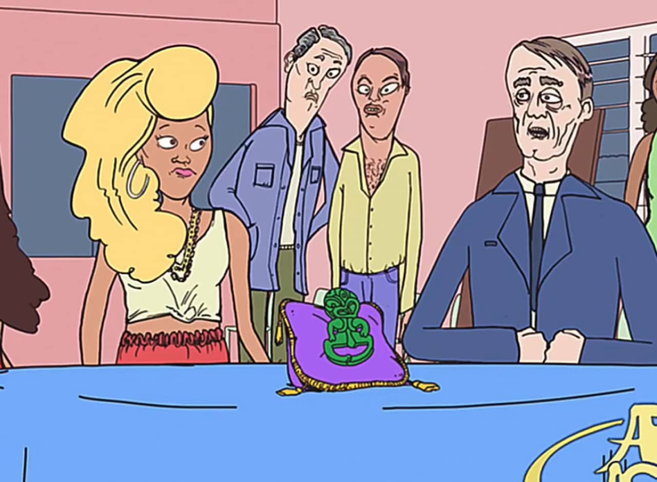 blonde woman sits at a table with an old man, an artifact is sitting on a pillow on the table