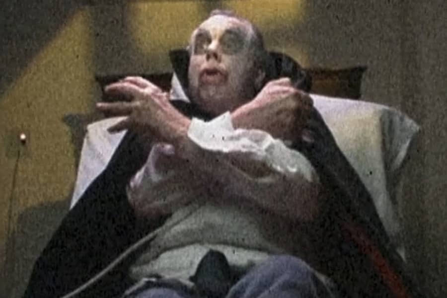 Dracula crossing his arms as his hospital bed lowers