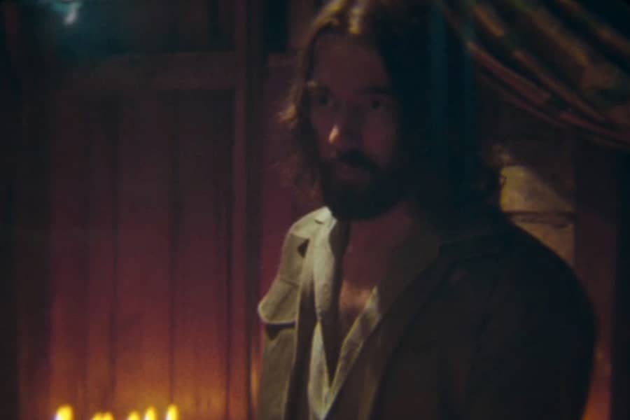 bearded man in a candlelit room
