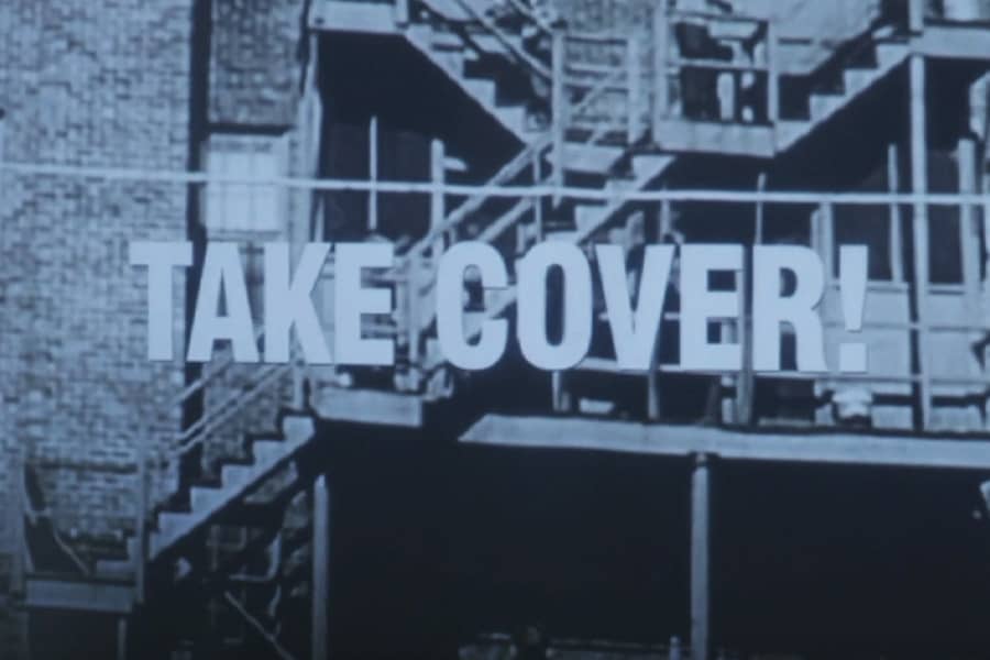 outdoor apartment stairs with text “Take cover!”