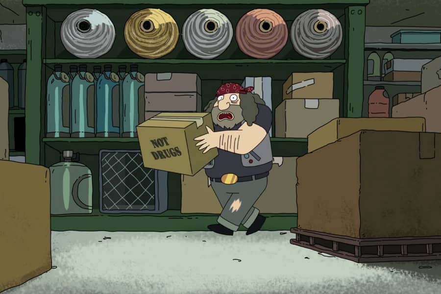 a rough looking man in a warehouse carries a box labeled “Not drugs”