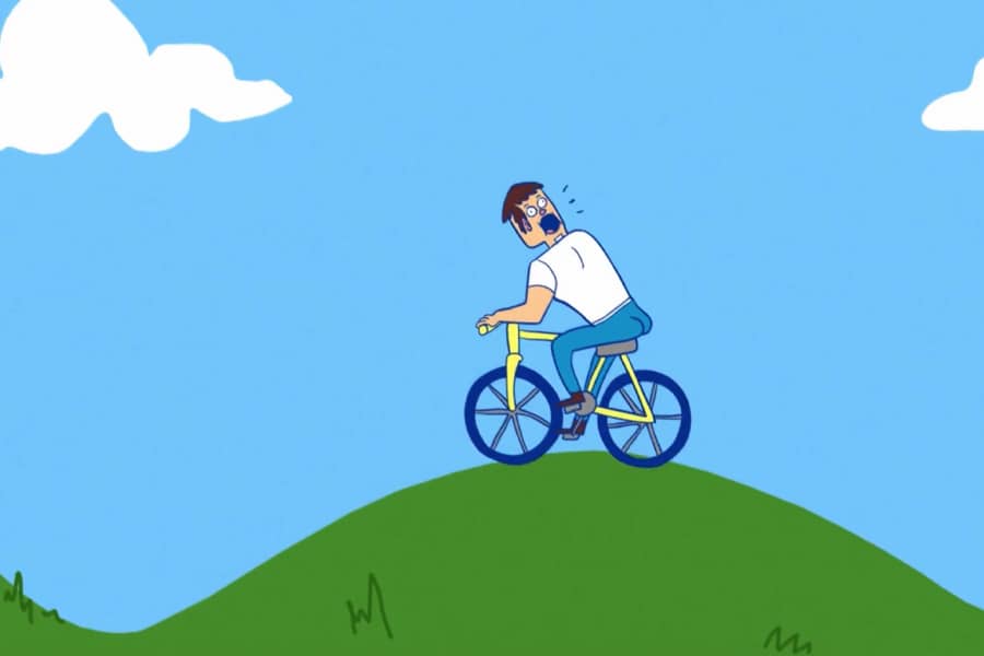 Backwards Gary screams as he rides his bike along a grassy hill