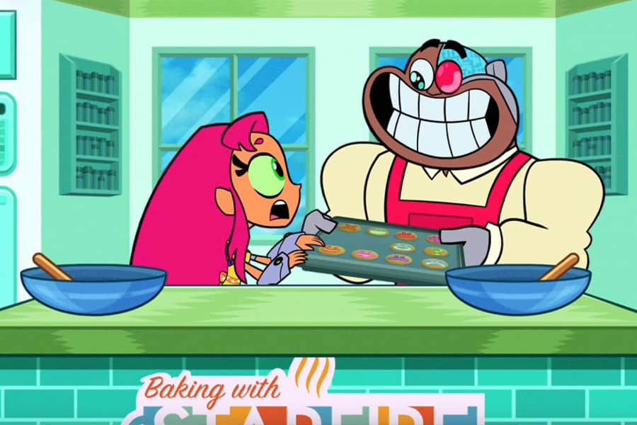 Cyborg with a huge smile, trying to pull the tray of cookies away from a concerned Starfire
