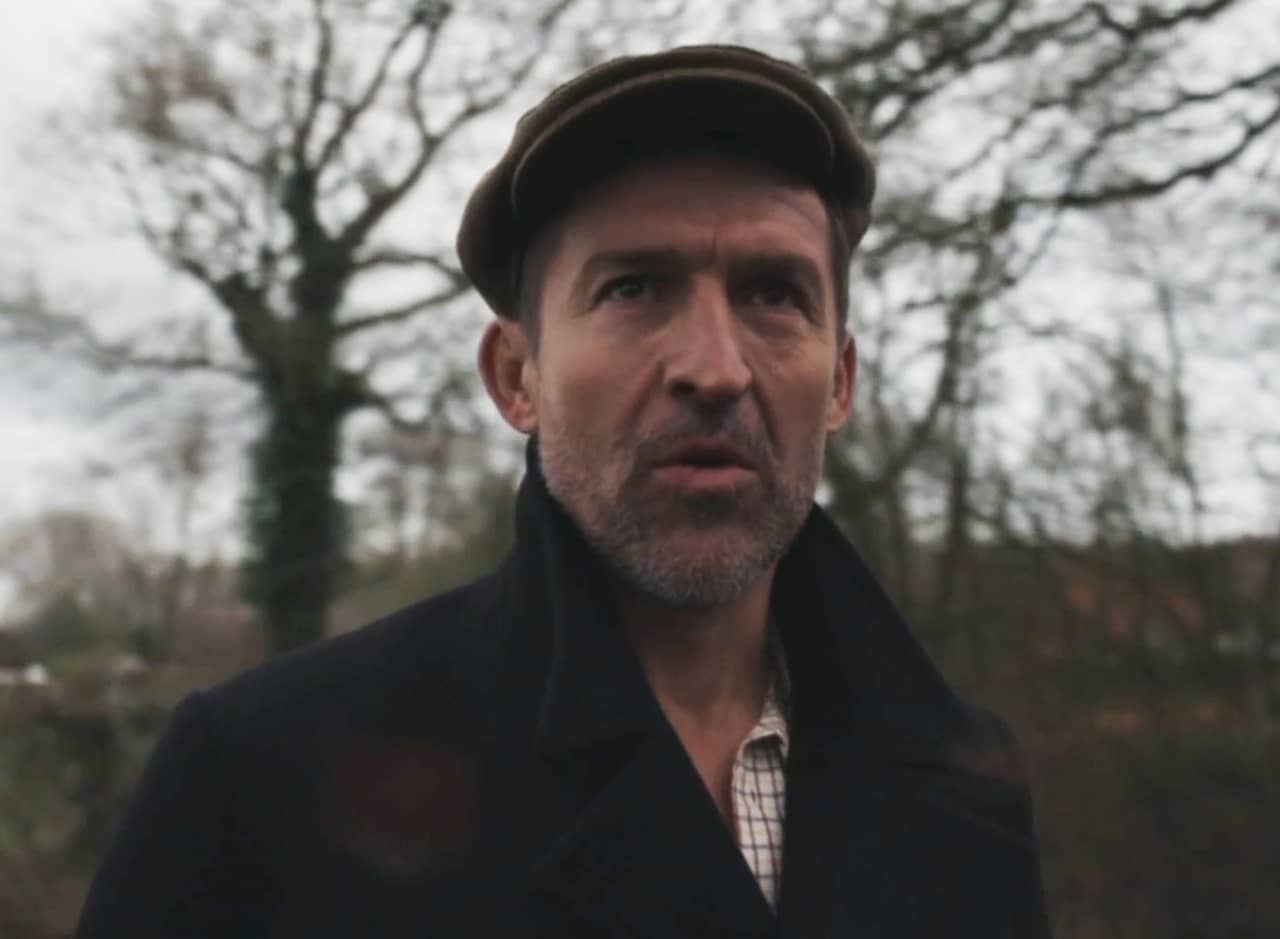 British detective, in a jacket and flat cap