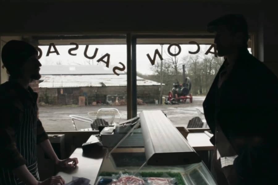 In silhouette, the detective speaks with a store clerk