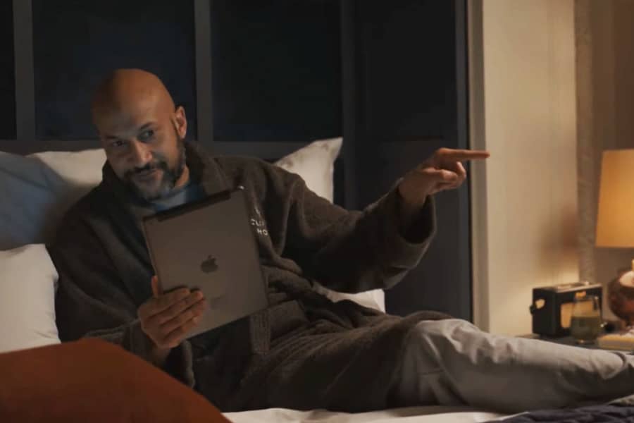 Sean Knox in a bathrobe in bed talking angrily at an iPad