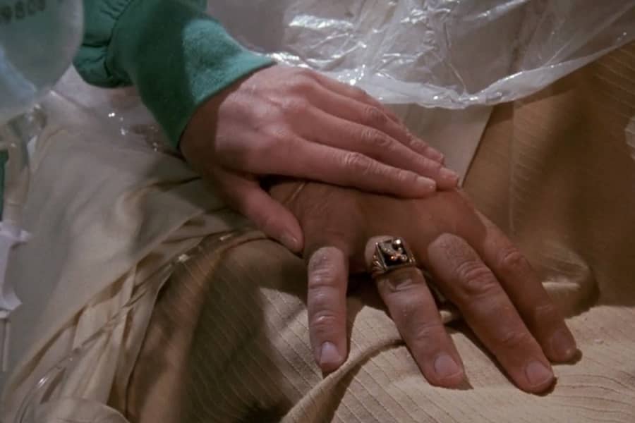 nurse Helen’s hand touches Carter Hedison’s hand