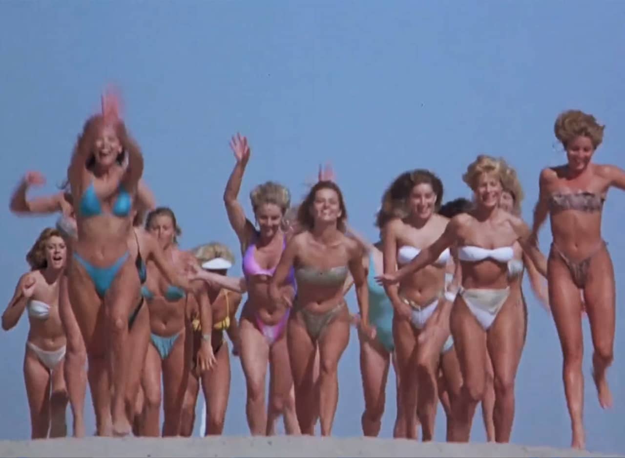 women in bikinis running on the beach