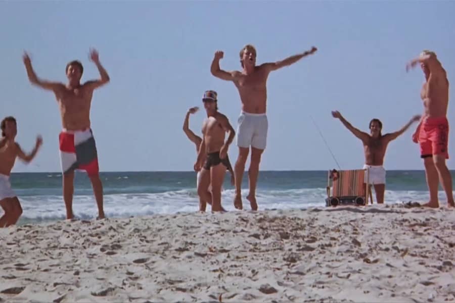men in swim trunks on the beach