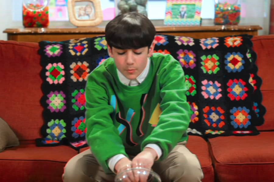 Lenny grabbing handfuls of candy while sitting on a couch