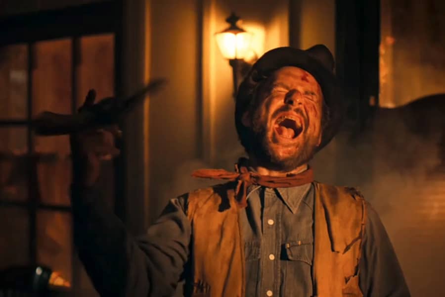 Billy the Kid cackling and spinning a gun on his finger