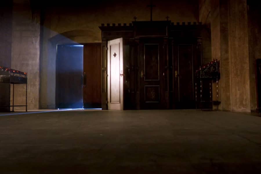 open door of a confessional in a dark church