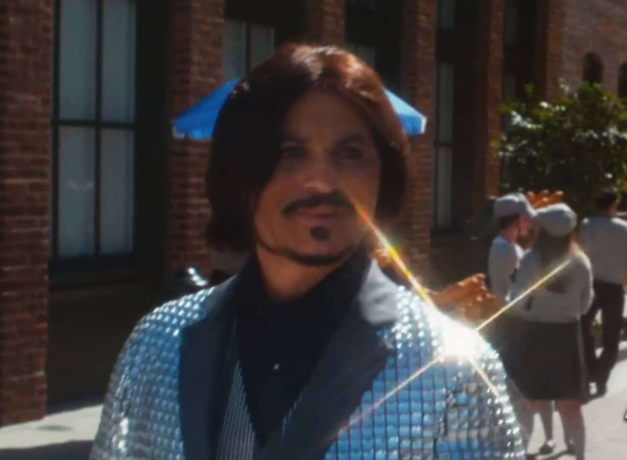 a Johnny Depp look-alike on a Paris street wearing a faceted, reflective suit