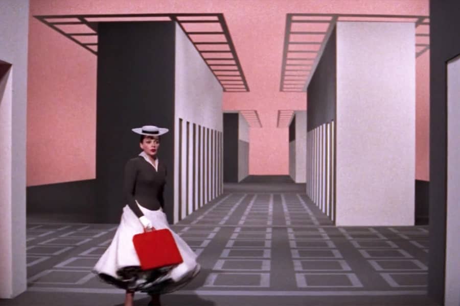 the woman walks in a surrealist building corridor
