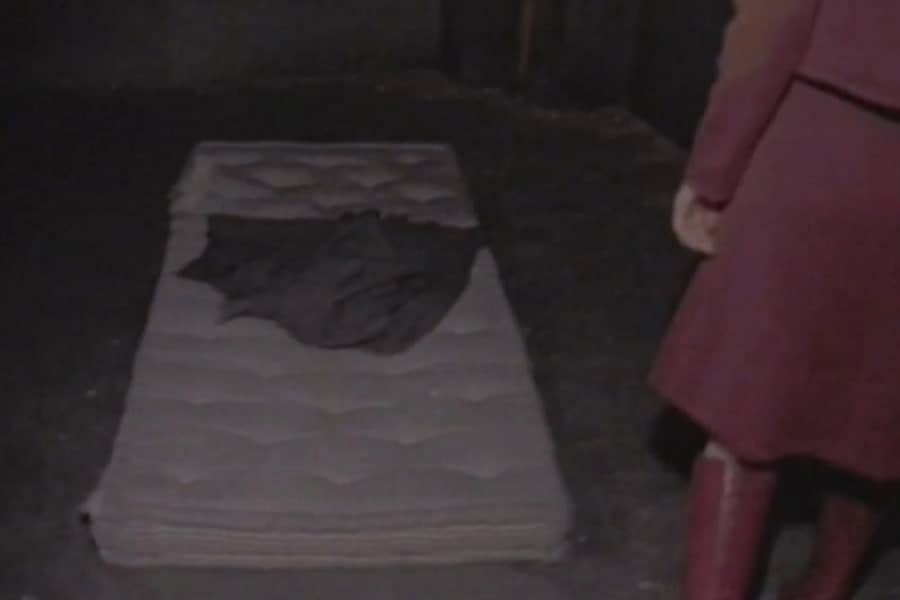 Winters stands by an empty mattress on the floor