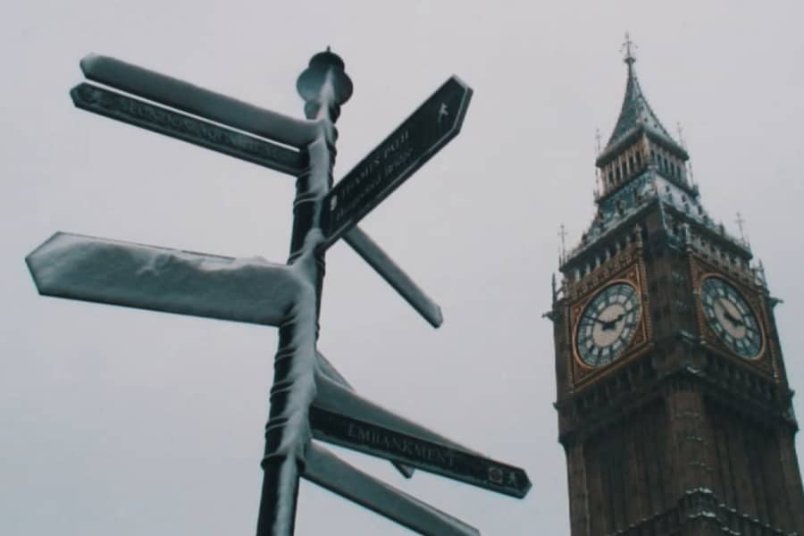 a snowy signpost in front of Big Ben