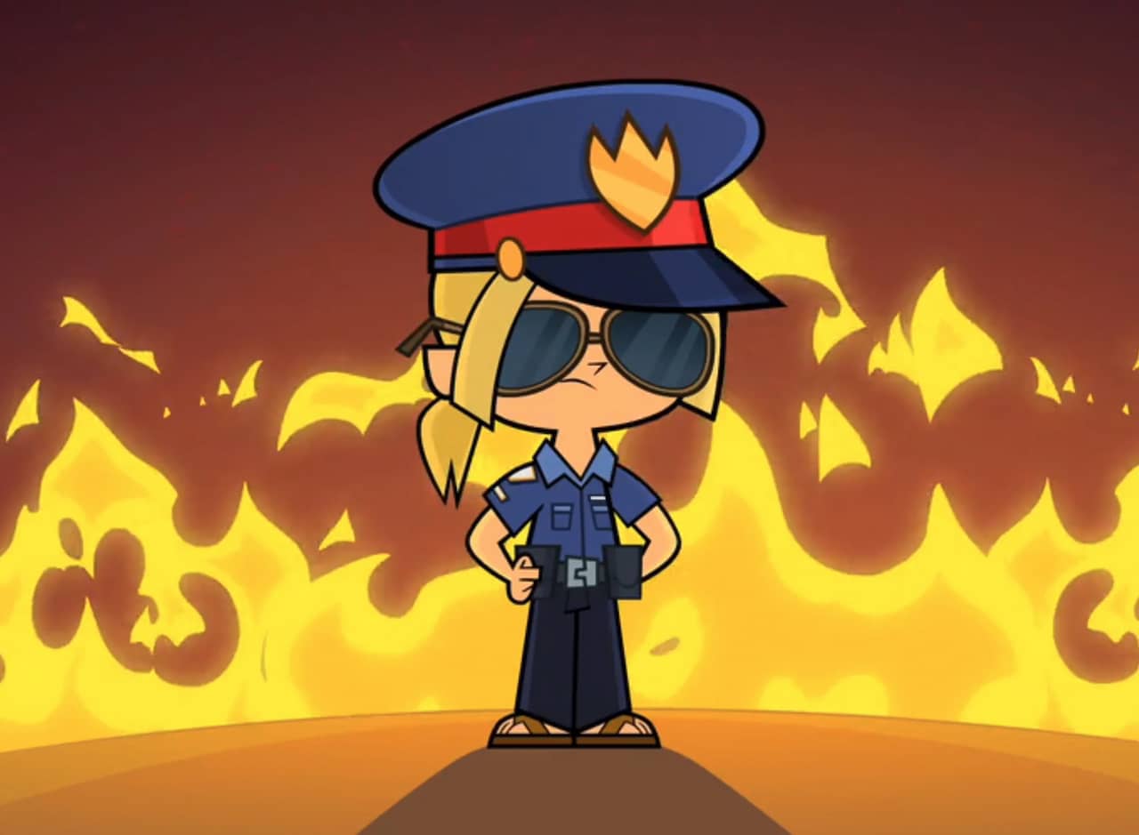 Bridgette, a small blonde child, dressed as a cop in front of flames