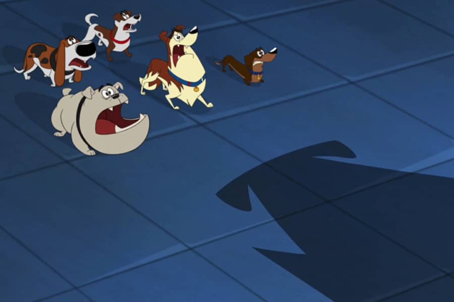a group of dogs looking scared as a large shadow looms