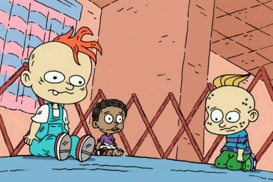 three sad looking toddlers in the pen