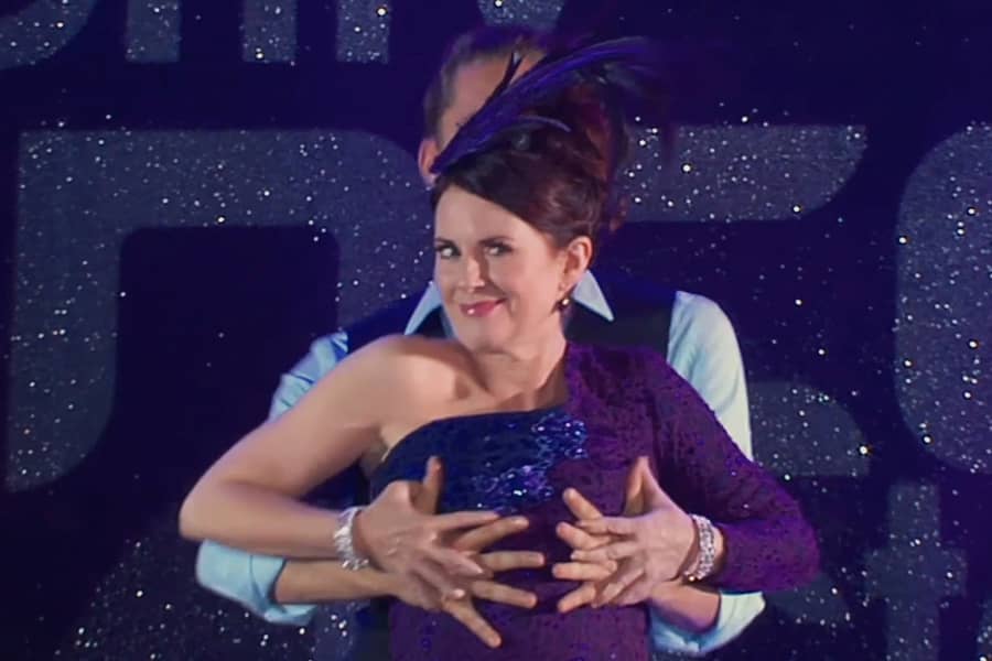 Megan Mullally with her dance partner’s hands on her breasts