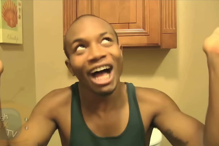 Charley laughing with his hands up while on the toilet