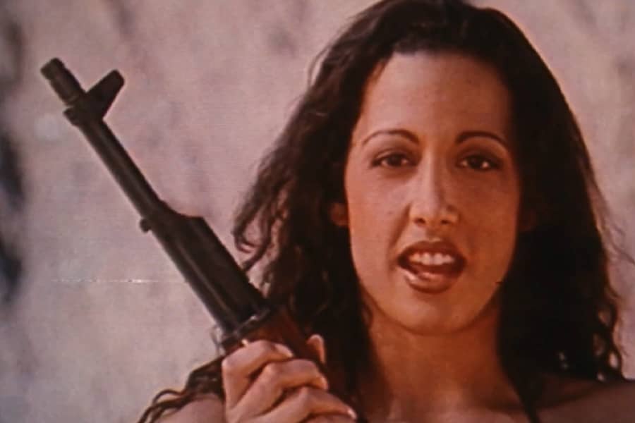 closeup of another brunette holding an AK-47