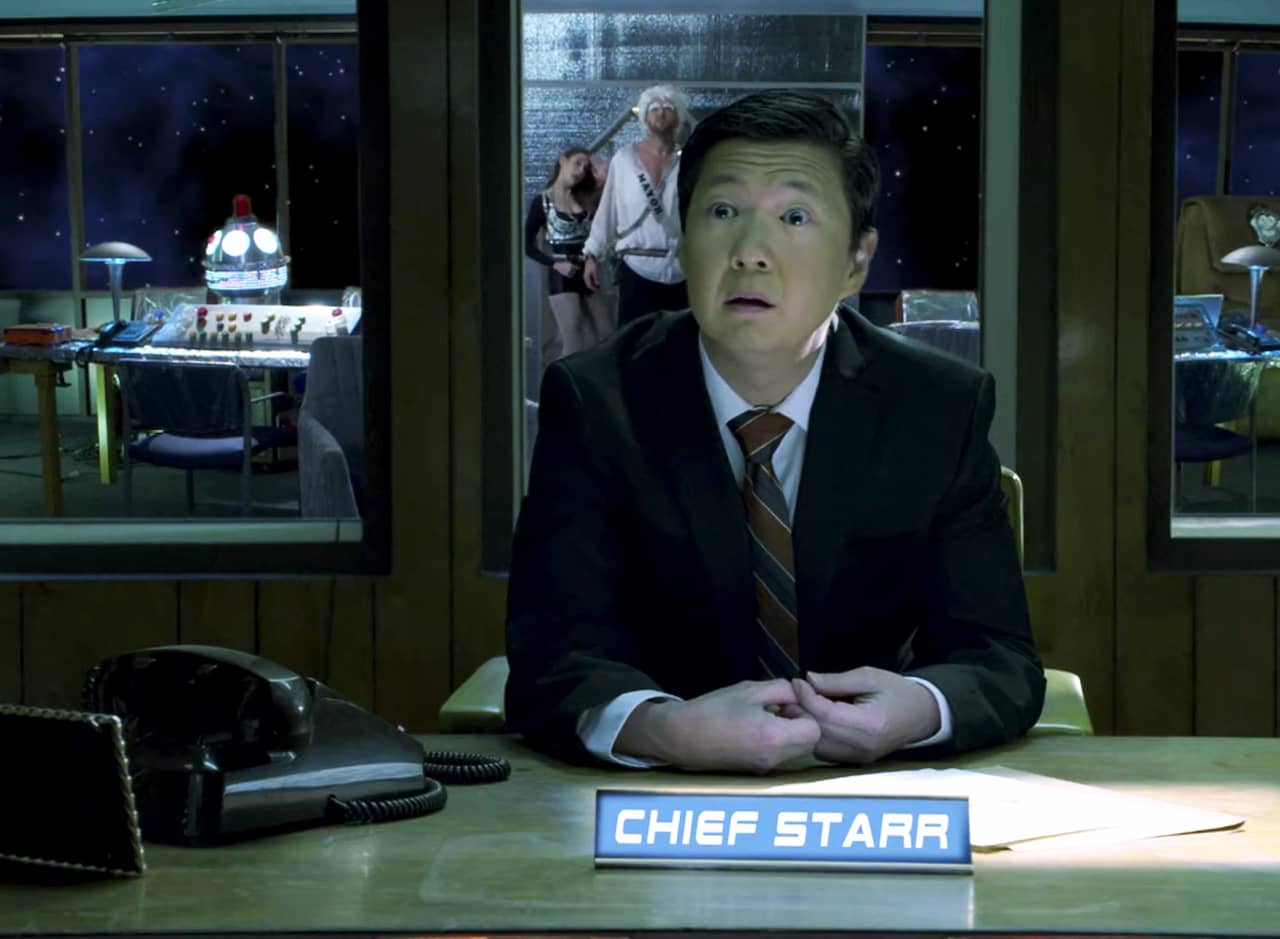 Chief Starr in a suit at his spaceship desk