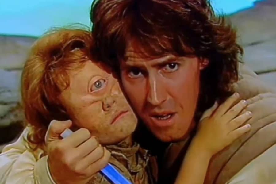 Romak holds a young boy with one eye