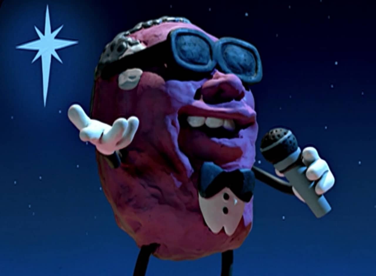 a singing claymation prune with sunglasses and microphone
