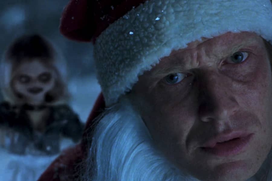 closeup of the man’s face as a sinister female doll approaches from behind