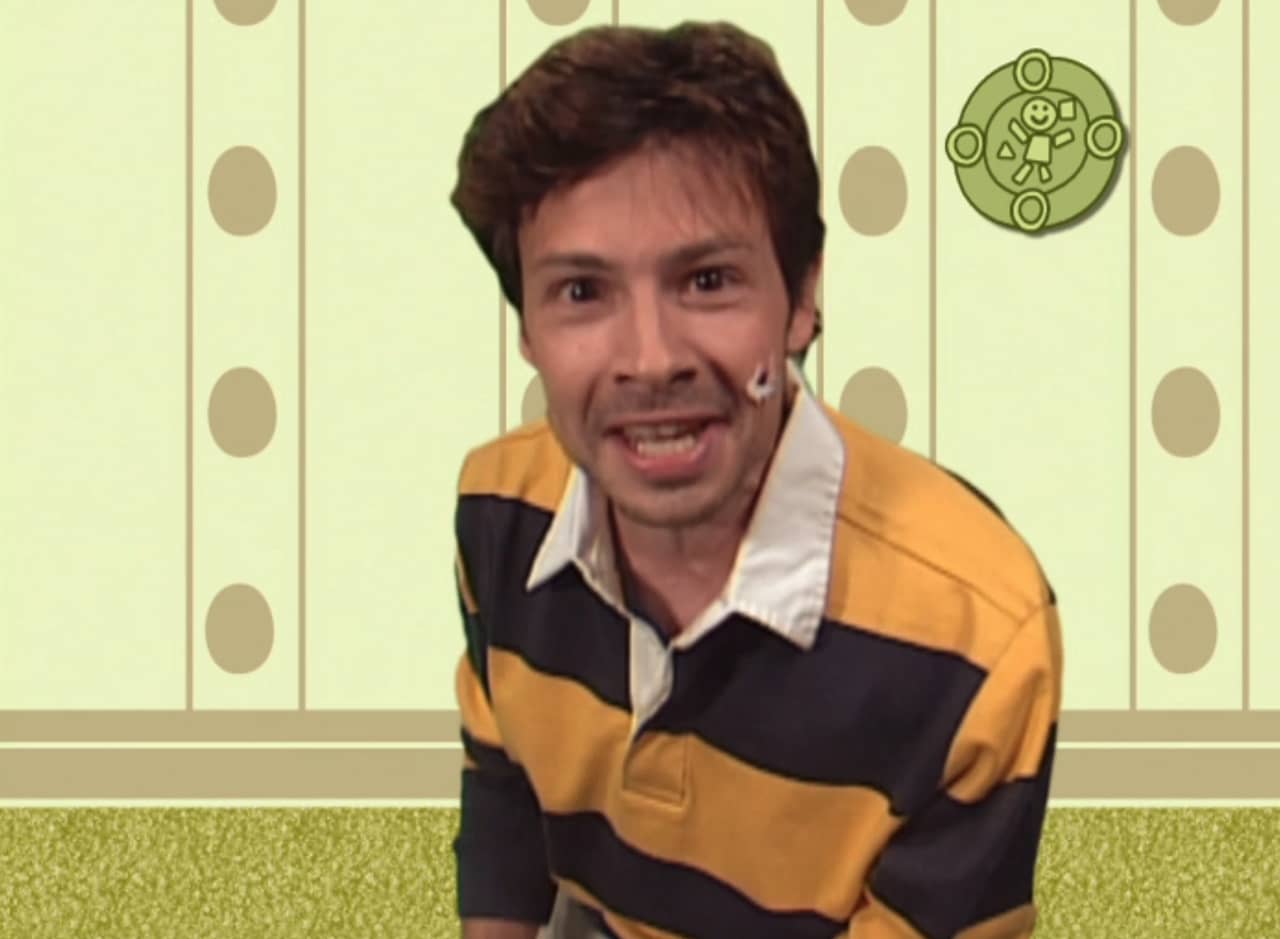 real human man in a striped shirt against a cartoon room background